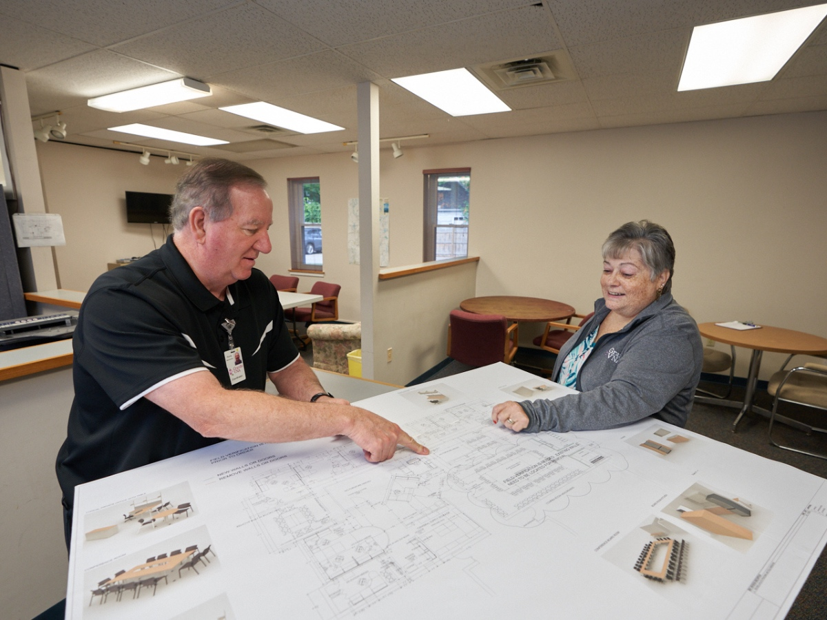 Randy Macdonald, M.Ed., M.PA, Volunteer Coordinator, and Dee Laurent, IT and Facilities Program Assistant, review the initial design for the community space in Laconia.