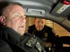 Captain James Brown in the cruiser conferring with fellow officer while monitoring incoming emergency calls on radio and computer. He's a HERO.