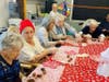Residents participate in chocolate-covered strawberry making at a group table.