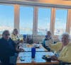 Residents enjoy a meal with waterfront views at a local restaurant.