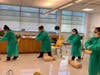 Socially-distant CNA students donning PPE practice abdominal thrusts on imaginary patients at NCC.