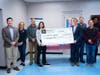 Pacific House board and staff members stand with 0&G leadership at a check presentation ceremony.