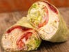 The Chicken Cranberry Wrap, made with chicken salad, Swiss cheese, cranberry sauce, tomato, red onion, and lettuce.