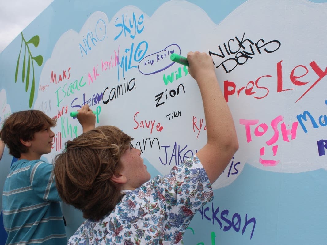Participants sign the Kindness Mural at the Boys and Girls Club of Malibu.