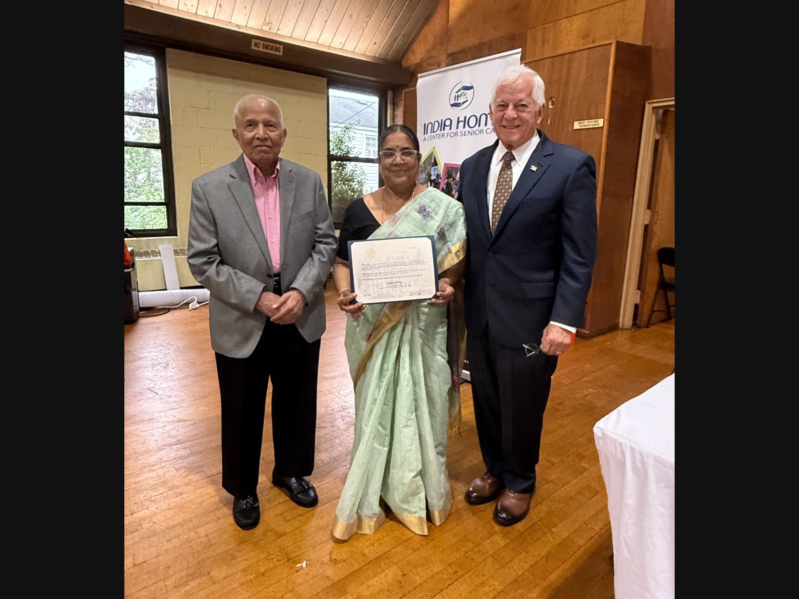 Lavine presents a citation to (l-r) Mukund Mehta, India Home Board of Directors President, and Dr. Vasundhara Kalasapudi, India Home Executive Director, at the grand opening of the India Home Senior Care Center in Hicksville, NY, July 7, 2026