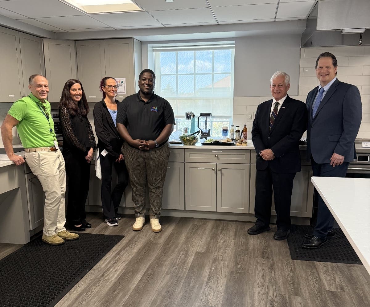 (l-r) Jim Spencer, Grant Writer; Lauren Accovelli, Chief Admin Officer; Susan Rust, Dir. of Culinary; Ayo Adewunmi, VP of Family Center of Achievement; Assemblymember Charles Lavine; John Pfeifer, CEO; Garden City, NY, Oct 14th, 2026 