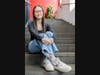 Amelia Khoo sits on stairs inside the Honors College at Rutgers-New Brunswick.