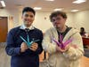 Christopher Godoy (left) and Eduardo Nunez hold origami birds during an October 2024 meeting for Bonner Leaders in Tillet Hall.