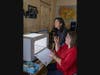 Lena Struwe (right), director of the Chrysler Herbarium, shows Sue Huang a lightbox and camera setup used to digitize plant specimens.