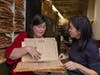 Lena Struwe, director of the Chrysler Herbarium, shows Sue Huang a plant specimen stored between sheets of newsprint in December.
