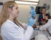 Alex Bell prepares a syringe in a simulation lab within the Ernest Mario School of Pharmacy.