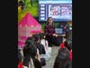 Evan Charles Keeton discusses a page from the children's book "Who's That Knocking on Christmas Eve?" with young students in the library of an elementary school.