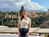 Rutgers graduate Victoria Richard stands before a view of the Alhambra, a fortress and palace complex in Granada, Spain.