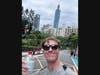 Standing before a view of skyscraper Taipei 101, Rutgers graduate Jack Wooks snaps a selfie before starting to walk the Elephant Mountain trail.