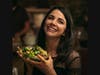 A young woman holds up a bowl of salad in a scene from "Love New York."