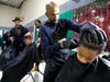 Fourth grader Isaiah Robinson gets a haircut at school during the Illinois School Holiday Haircuts event.