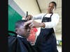 Third grader Kaysen Williams gets a holiday haircut from one of the barbers from Phipps Academy of Barbering.