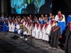 Radio personality Ramonski Luv, who was the emcee for the evening, poses in front of the Commission Choir, a choir made up of students from Bloom Township, Rich Township, Southland College Prep, Hillcrest High School and Kankakee High School.