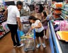 Derrick Wolf shops with his 8-year-old twin daughters, Evelyn and Aliyah, who are entering third grade. Making Disciples founder Eric Bassette surprised the family with a back-to-school shopping spree during the July 31 shopping trip.
