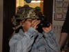 A student tests out night vision goggles in a darkened classroom.