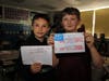 Two students show off their handmade cards that will be sent to Special Forces soldiers.