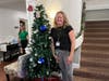 Team members stand proudly next to their festively decorated trees, competing for the grand prize at the annual Festival of Lights.
