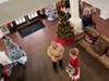 An aerial view captures the festive atmosphere as residents and staff gather around the decorated trees during the celebration.