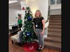 Team members proudly stand next to their decorated Christmas trees, competing for a grand prize at the annual Festival of Lights celebration.