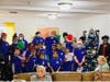 Young carolers from First Bethel Baptist Church fill the room with holiday cheer during a special event featuring hot chocolate and eggnog.