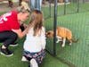 Young Girl from Place of Hope Learns how to Interact with a Dog from Big Dog Ranch while Giving A Treat 