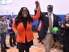 Edgar Allan Poe Classical Elementary School Principal Eric Dockery leads teacher Comfort Agboola, still reeling with shock, to the front of the assembly, where a crowd of dignitaries waits to present her with her Milken Educator Award. 