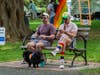 Friends relaxing on a bench alongside their rainbow-clad pooch at Ridgefield Pride in the Park 2026.
