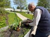 A resident tends to his garden bed in the outdoor space at Ridge Crest 