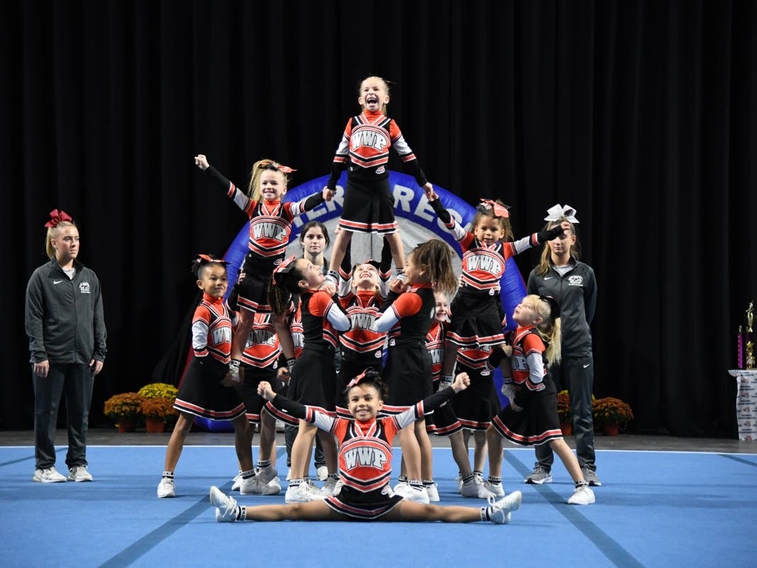 Radiant with joy, the WWP Wildcats Tiny Mites, aged 6-8, perform their pyramid stunt. These spirited young athletes, hailing from West Windsor-Plainsboro and Cranbury school districts, exemplify teamwork, resilience, and the strong ties of friendship.