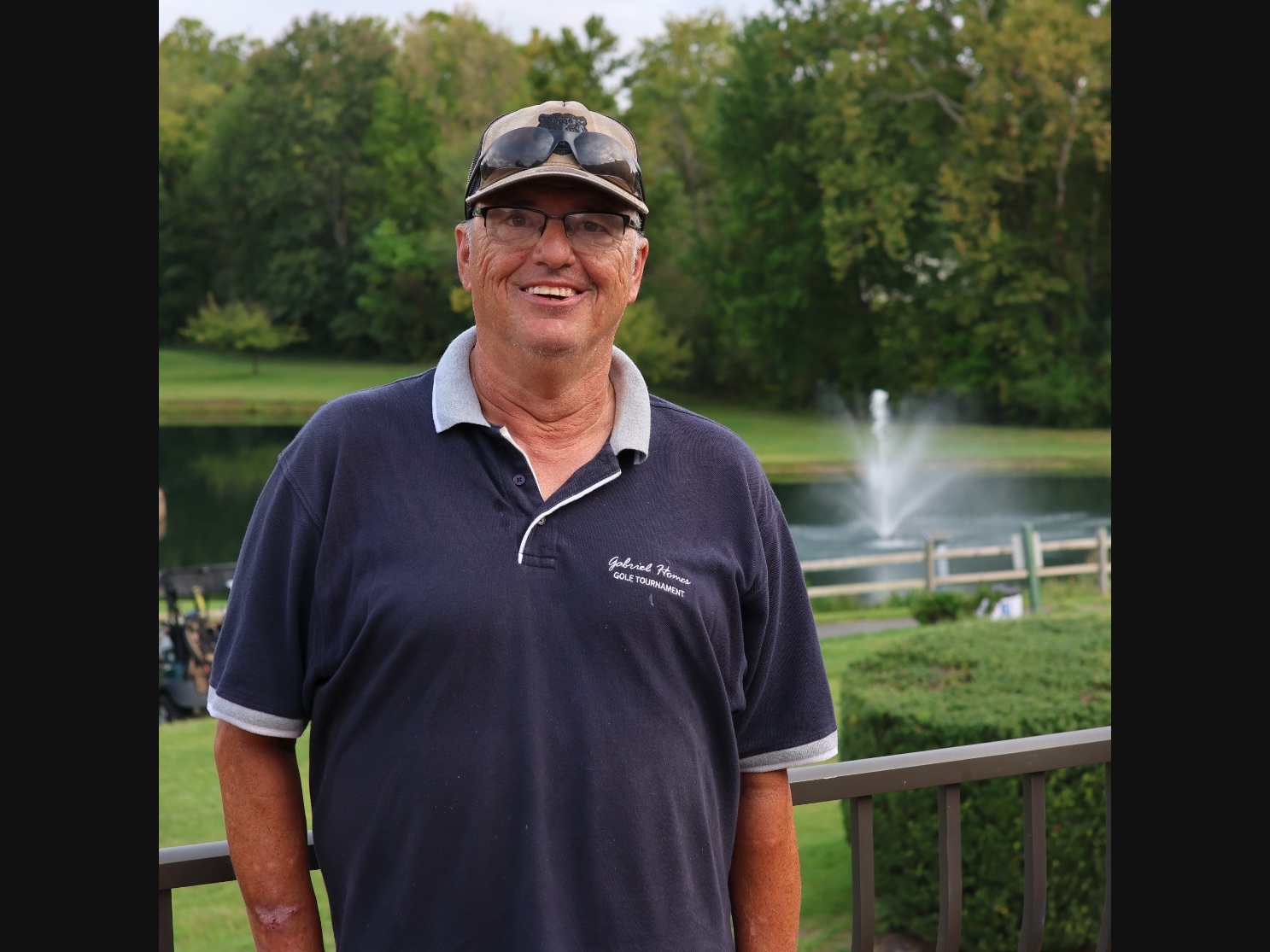 Gabriel Homes resident wearing a golf polo in front of a fountain.