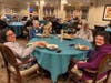 The dining room comes alive with conversation and laughter as residents savor their gourmet meal.
