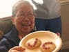A resident proudly displays freshly baked Valentine cookies decorated during the MLK Day service event.