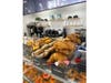 Croissants, Blueberry Bagels and other food items in a Bagel Bar display case.
