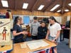 Jessica Marshall from the Freehold Township Historical Preservation Commission shares spy maps of Freehold Township with Clifton T. Barkalow Middle School seventh grade students Gaige Burke and D. J. Serafino.