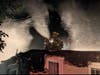 A firefighter on top of the Chestnut Street home.