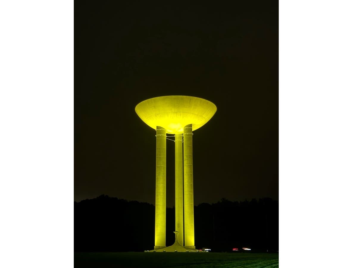 The Bell Works Water Tower lit up yellow.