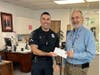 City Clerk Pete Smith presents Officer Cox the #1 license.