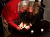 Steen Metz of Lincolnshire, a Holocaust survivor from Denmark, lights one of the candles with assistance from Amanda Friedeman, associate director of education at the museum.