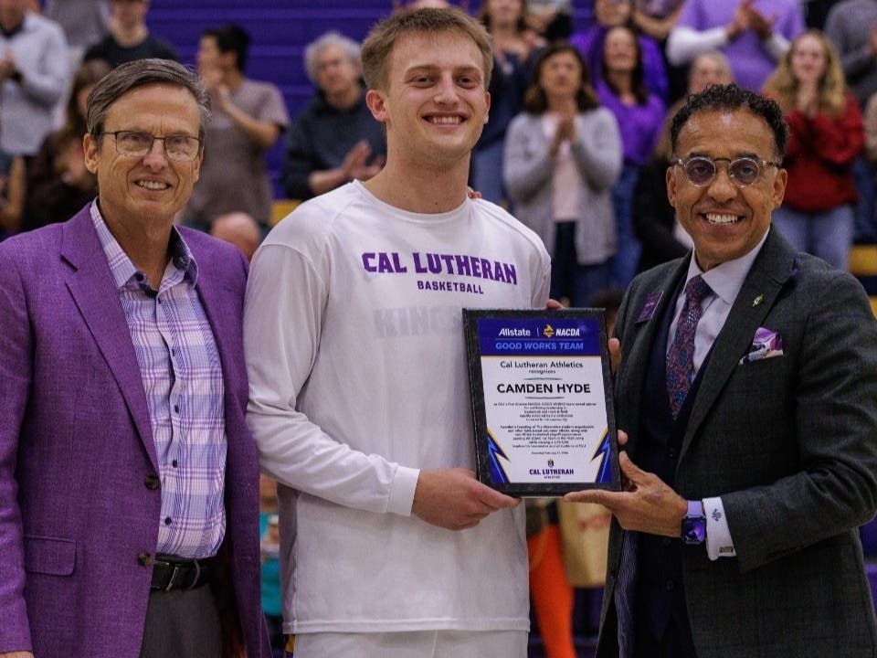 Camden Hyde, center, was named to the Allstate NACDA Good Works Team (Winter). Presenting the award at the Feb. 21 game are President John Nunes, right, and Howard Davis, associate vice president and athletics director.