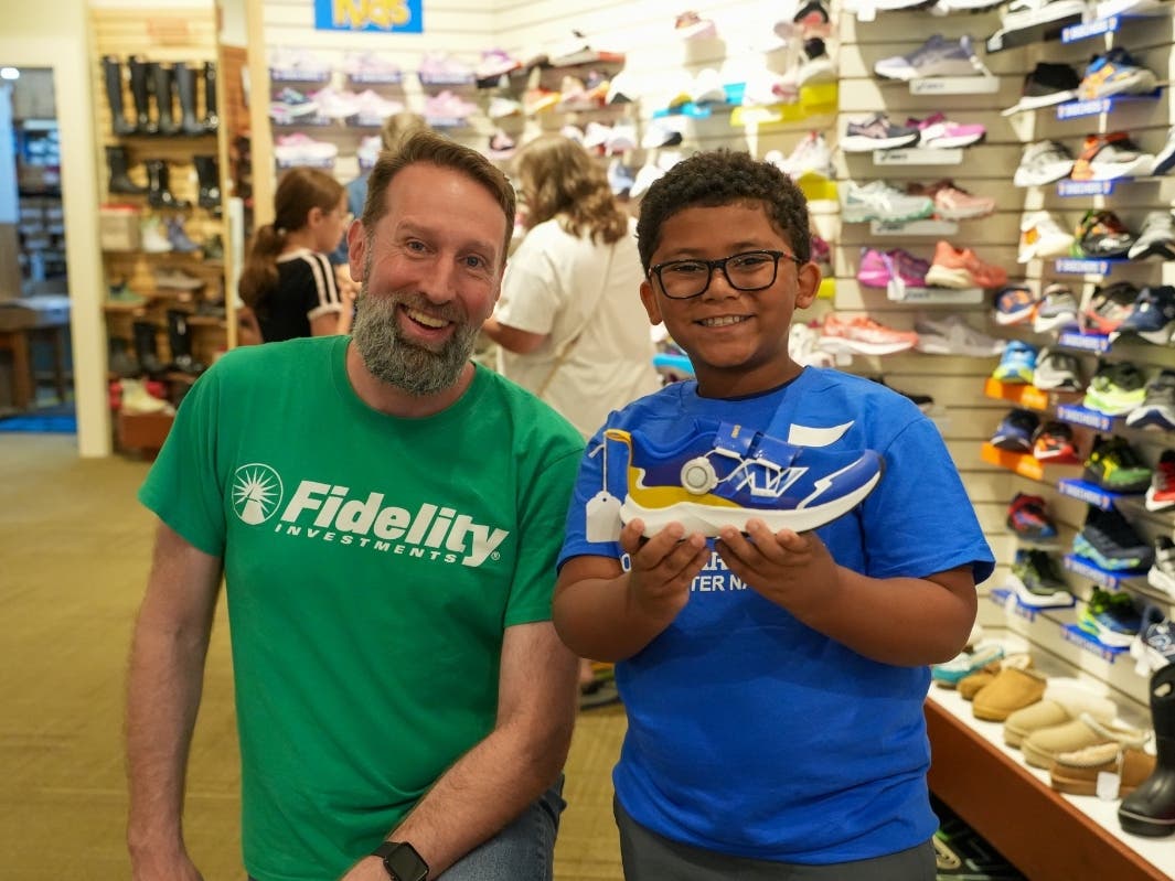 A Club member celebrates their shoe selection with a Fidelity volunteer