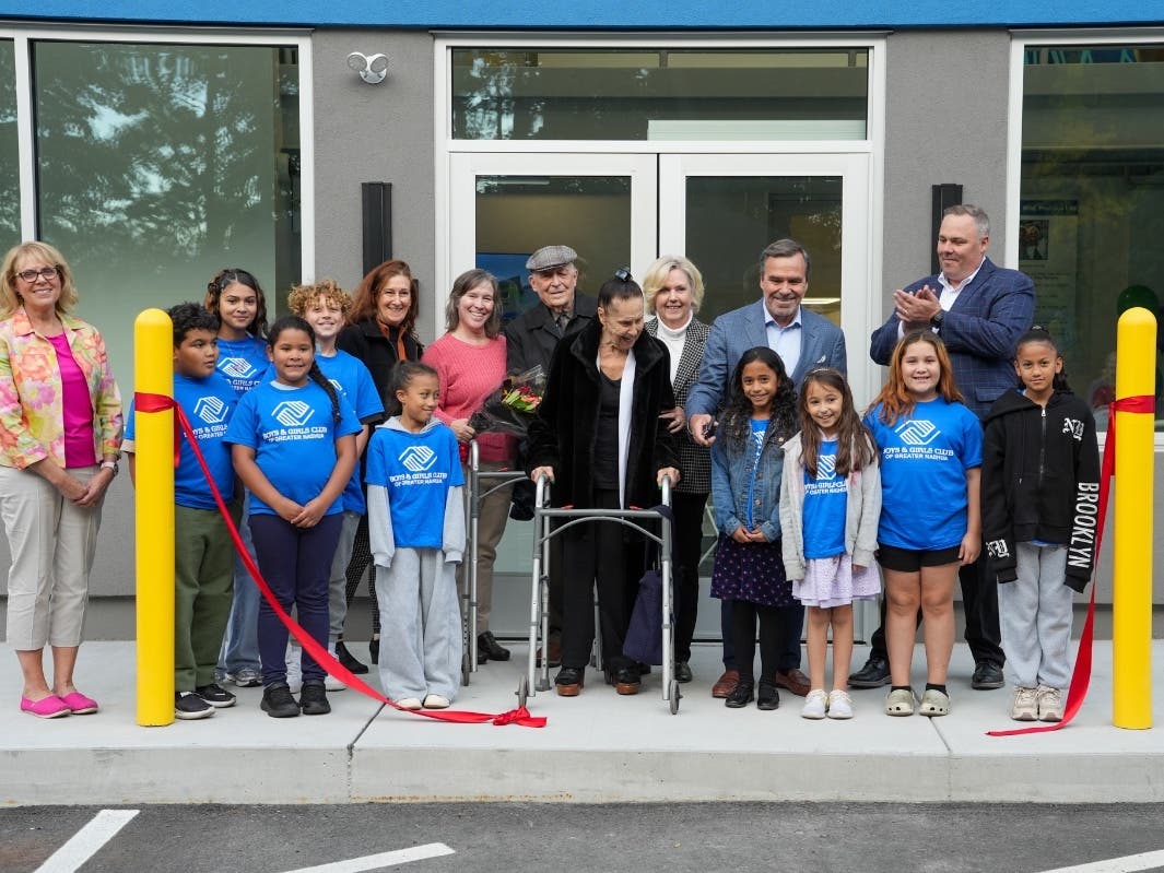 John Dionne cuts the ribbon alongside Club members, his wife Jacquelyn, family members,
﻿and Club Executive Director Craig Fitzgerald at the opening of the Dionne Family Entryway.