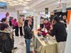 Timombe Paige (right) confers with business partner Kimberly Booke (maroon dress) during the recent Movie-Wine event at TownMall Westminster.