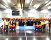Participants gathered for a group photo with a banner commemorating the UN's recent designation of July 12 as the International Day of Hope, captured during a basketball game.