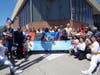 Attendees pose for a group photo with a banner celebrating the UN's recent declaration of July 12 as the International Day of Hope during the Haitian Flag Day Celebration.