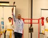 Dr. Juan Tapia-Mendoza, founder and CEO of Pediatrics 2000, is posed to ring the Bell of World Peace and Love.